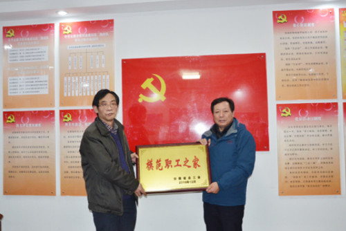 图为省能源化学工会主席王健（左）为二队颁发“模范职工之家”奖牌